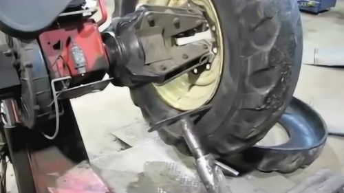 國(guó)外修車廠給拖拉機(jī)更換外胎的拆胎操作